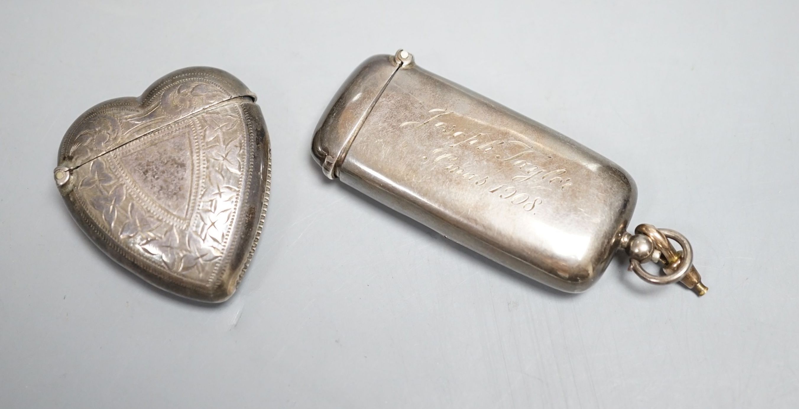 An Edwardian silver combination sovereign and vesta case, Robert Pringle & Sons, Birmingham, 1907, 62mm, with engraved inscription and a later Victorian silver heart shaped vesta case, Birmingham, 1897.